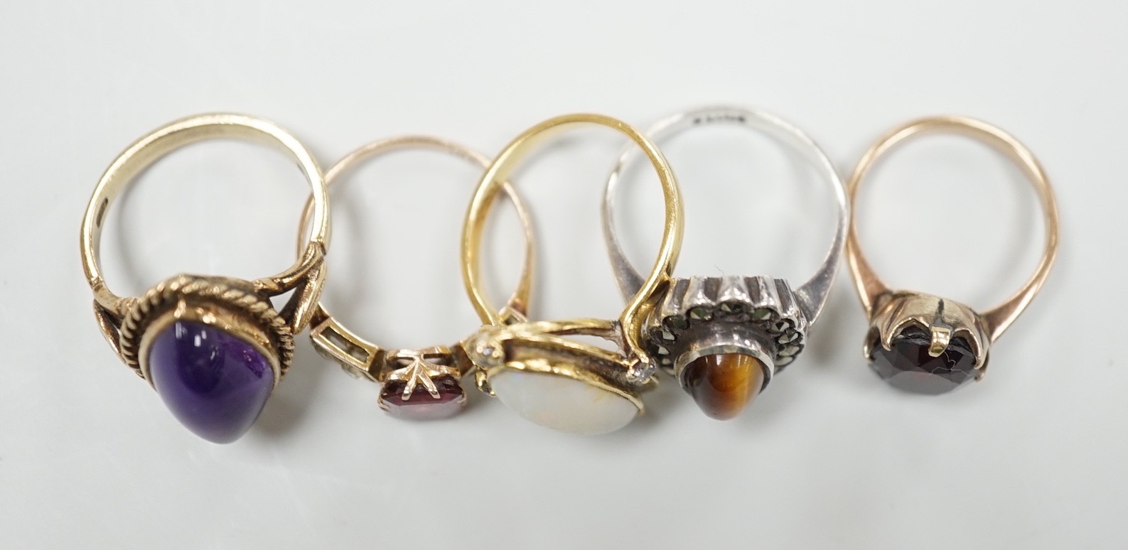 An 18ct, white opal and diamond chip set oval dress ring, size M, gross 4.8 grams and three other assorted 9ct gold and gem set dress rings, gross 10.3 grams and a white metal ring.